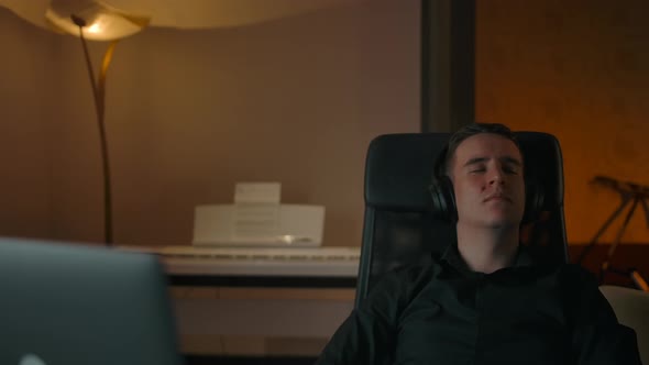 Caucasian Man Relaxing on Armchair in Cozy Home While Listening Music