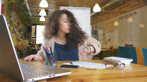 Young Happy Woman Working in the Office Writing Something and Using Computer