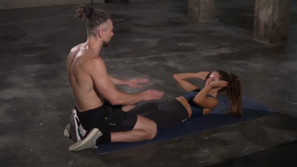 Young Stylish People Sporty Man and Woman are Doing Situps and Clapping Hands Training Together at