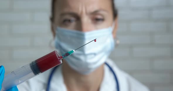 Lab assistant with blood syringe. 