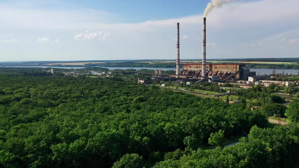 Industrial place from above. Flying above factory surrounded by green trees