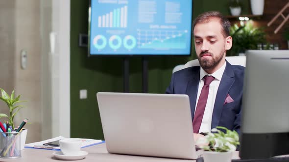 Businessman in Modern and Creative Office Space Working on a Laptop