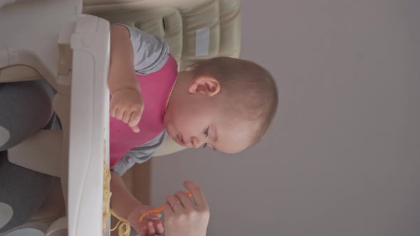 Mother's hand to feed baby 12-17 months spaghetti