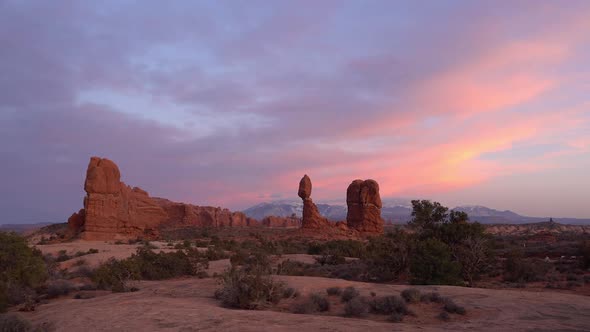 Wide panning view of Balanced Rock in Arches during colorful sunset