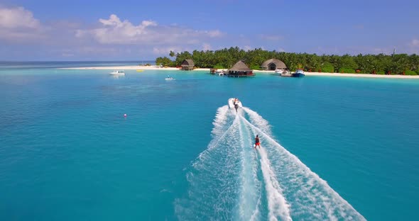 Aerial drone view of a man water skiing near a tropical island