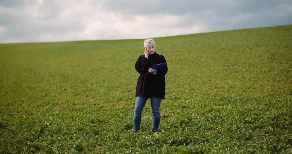 Female Farmer Examining Oilseed Rape Field