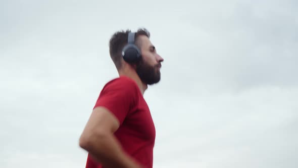 Man in an Athlete in Red Is Jogging in an Urban Environment