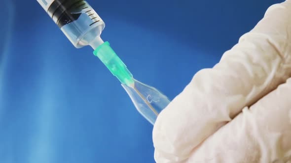 Doctor Filling Syringe with Medicine from an Ampoule 