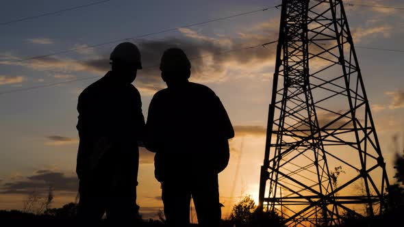 Engineers Shaking Hands at the Construction of High-voltage Power. Teams Engineer Looking Discussing