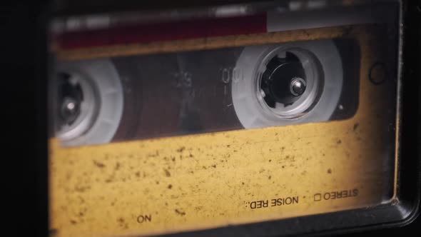 Vintage Yellow Audio Cassette Playing in Deck of an Old Tape Recorder