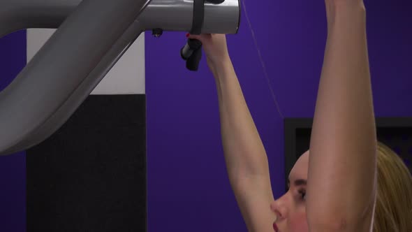 A Young Beautiful Woman Does Pull-ups in a Gym - Closeup From the Side