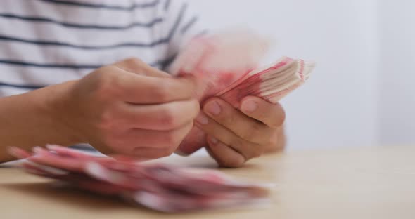 Man counting the number of RMB at home