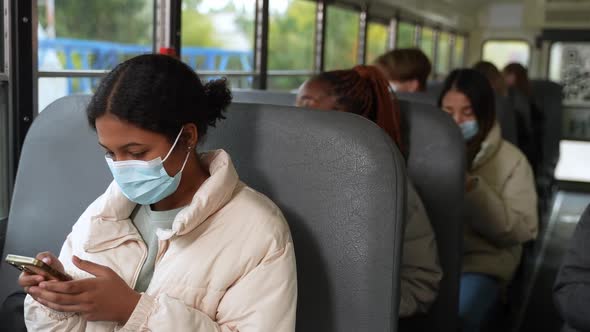 Multiethnic Pupils in Face Masks Riding School Bus