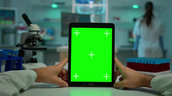 POV Shot of Chemist Using Tablet with Green Screen in Laboratory