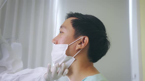 Medical Worker in Ppe Suit Swab Testing for Covid19 Sample From Mouth of Infected Man in Hospital