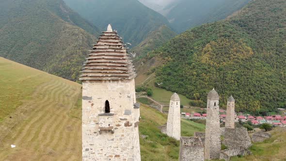 Aerial View of a Row of Ancient Watch Towers in a Valley Among High Green Mountains