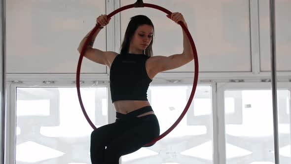 Gymnastic Training  Young Woman with Tattoo Does Acrobatic Stunts on an Acrobatic Ring