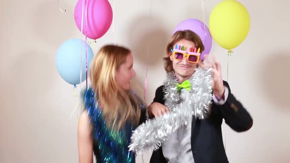 Happy woman and man dancing in photo booth