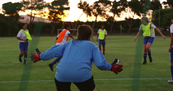 Female soccer players passing the ball while female player falls down. 4k