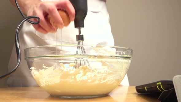 Adding egg to bowl with cake mix and whisk