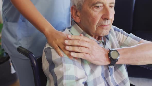 Video of midsection of biracial female doctor taking care of caucasian senior man