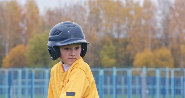 Portrait of a Boy Baseball Player on a Blurry Background, the Batter in Protective Gear Waiting for