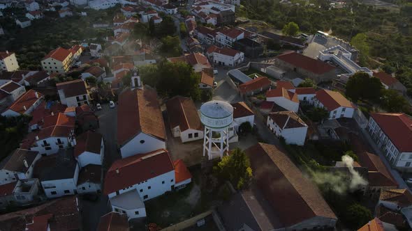 Drone flies over downtown Belmont seeing the local water tower and the orange tile rooftops