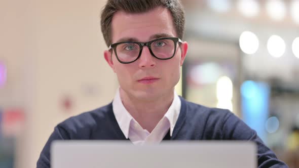 Young Businessman with Laptop Looking at the Camera 