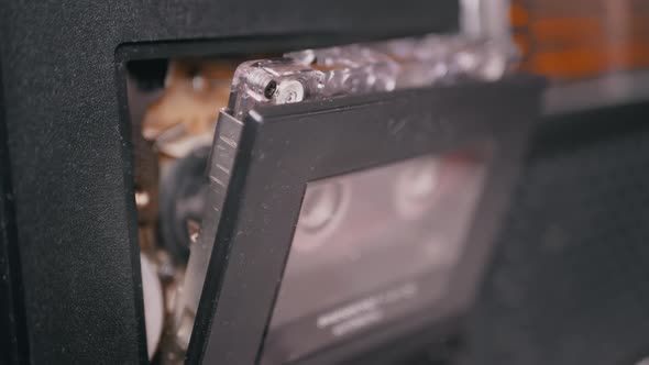 Female Hands Take Out an Old Audio Cassette From a Vintage Tape Recorder