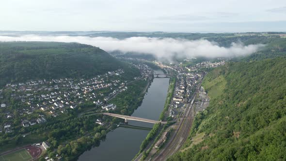 Aerial time lapse of morning fog rolling through the moselle valley in Cochem, Germany. Static wide