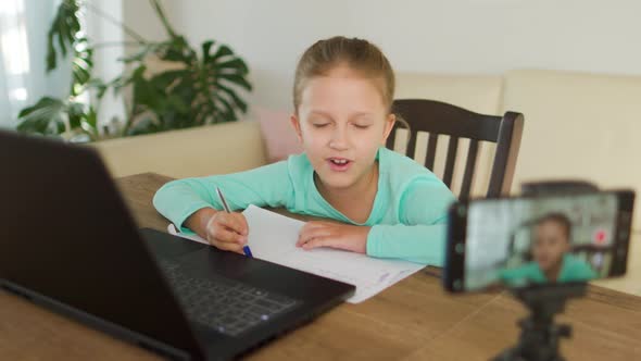 Schoolgirl Girl Doing Homework On Distance Learning