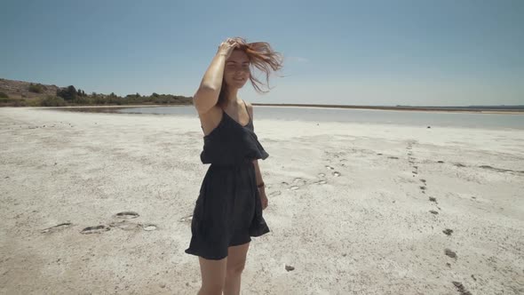 Beautiful Redhaired Woman Walks and Has a Good Time on a Dry Salt Lake in France
