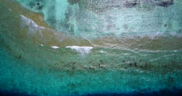 Natural flying tourism shot of a white paradise beach and turquoise sea background in 4K