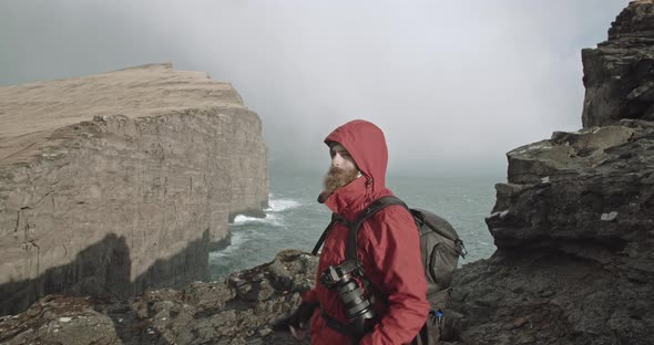 Man detaches camera from backpack