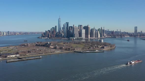 An aerial view of New York harbor on a sunny day with clear blue skies. The camera tilt down over th
