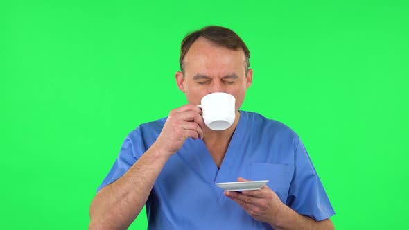 Medical Man Enjoying Coffee on Green Screen.