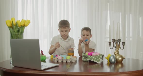 Two Boys Paint Easter Eggs and Greet Each Other