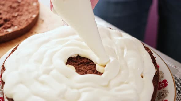 Baker Woman Applies Cream on Cake Shortcakes in a Bakery