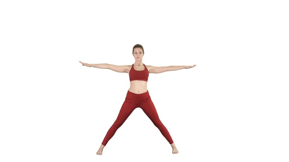 Young woman in forward bending asana yoga pose on white background.