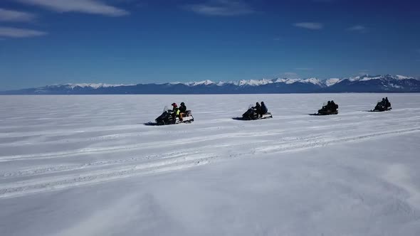 Aerial View Snowmobiles Ride on the Frozen Lake Baikal in Winter