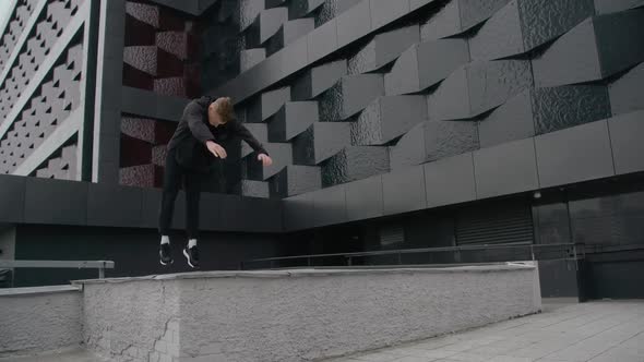 Young Man Does Flips and Jumps Parkour on Modern City Free Running in  Slow Motion