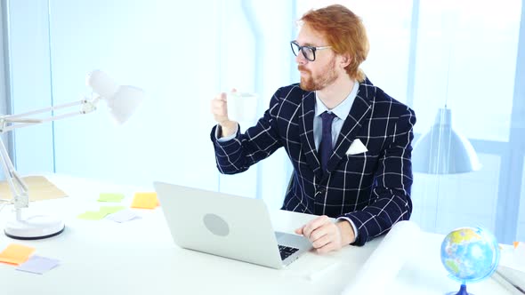 Redhead Businessman Drinking Coffee at Work, Relaxing Freelancer Designer