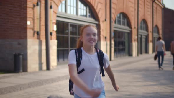 Happy Redhead Schoolgirl Running with Backpack After School.