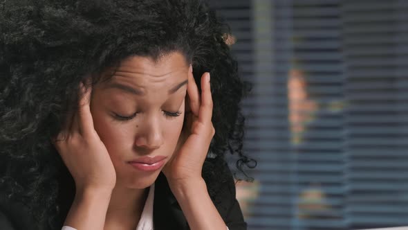 Portrait of African American Woman in Business Suit Suffers From Overwork and Headache