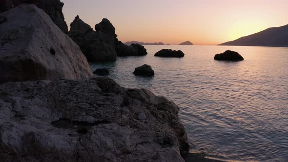 Relaxing Ocean Waves and Huge Rocks on Tropical Beach at Sunset