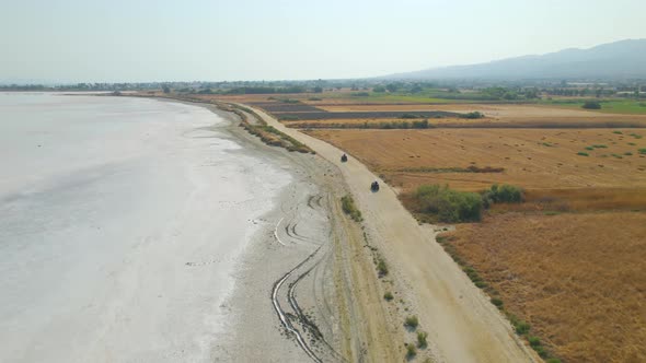 Aerial view following behind ATVs by salt lake, Kos, Greece