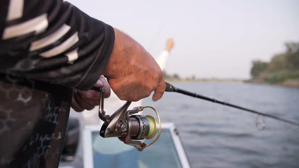 fishing rod in the hands of a fisherman at sunset