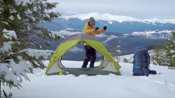 Tourist Relaxes in a Tent in the Mountains in Winter