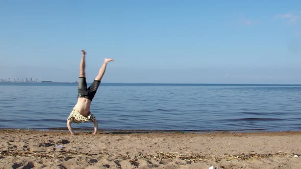 Happy Tourist Jumps on the Beach Like a Gymnast in a Hawaiian Shirt Along the Sea Line From the