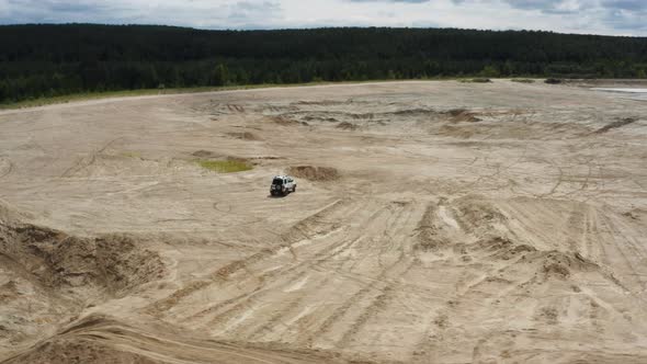 Aerial View of a Car Driving on Sand